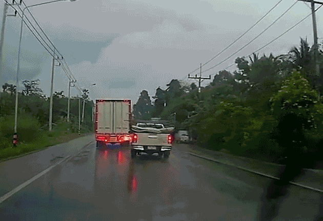 Trời mưa, đường trơn khiến bán tải vượt ẩu húc xe tải lật nghiêng bên vệ đường